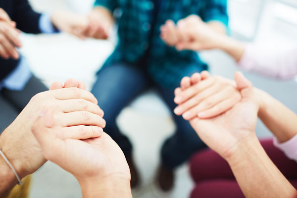 support group holding each other's hands